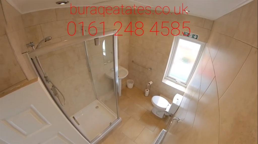 Bright, modern tiled bathroom with a corner gla...