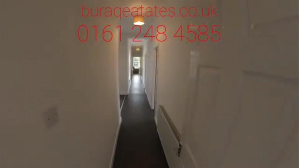Bright, long hallway with clean white walls, da...