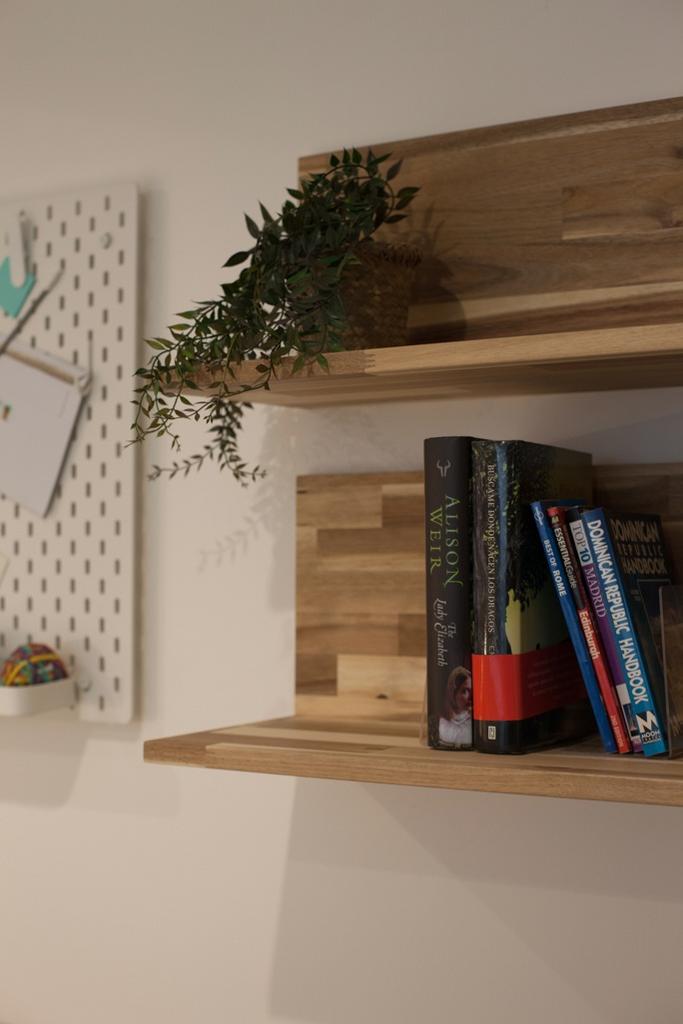 Neatly styled wooden wall shelves with a potted...