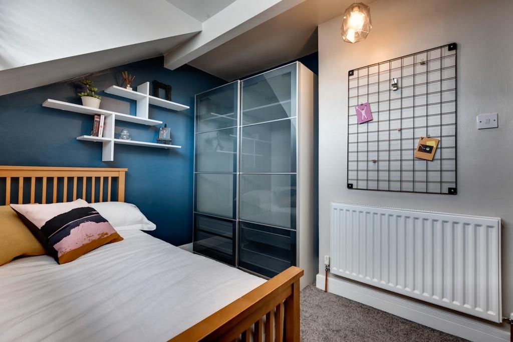 Bright, contemporary bedroom with a wooden bedf...