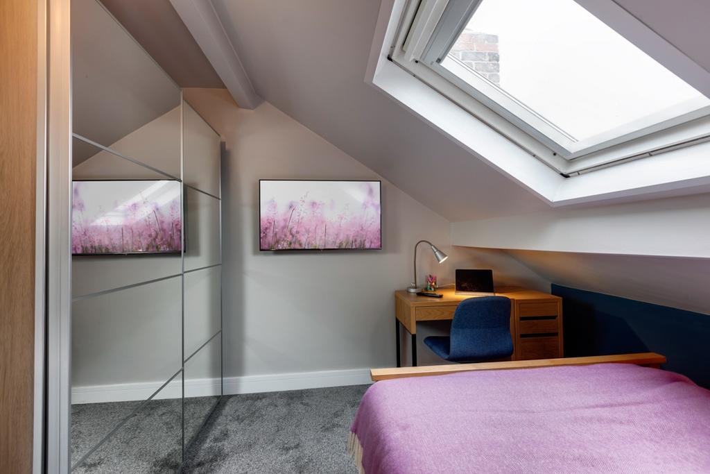 Bright attic bedroom with a large skylight, mir...