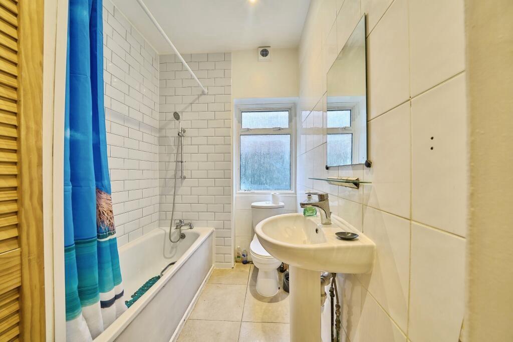 Bright, modern bathroom with a white subway-til...
