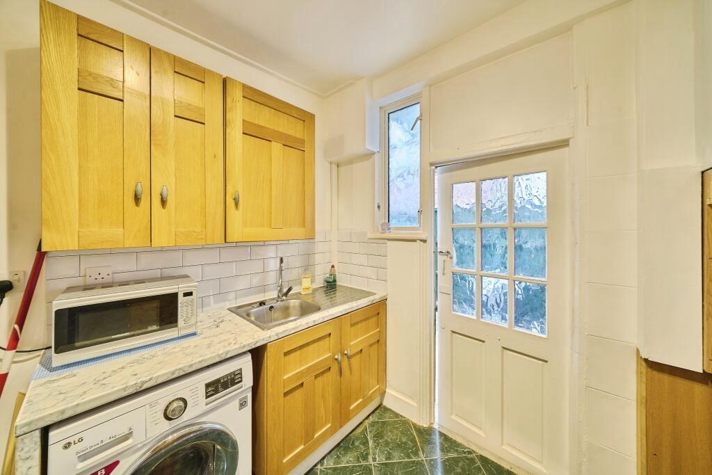 Compact, well-kept kitchen with wooden wall and...