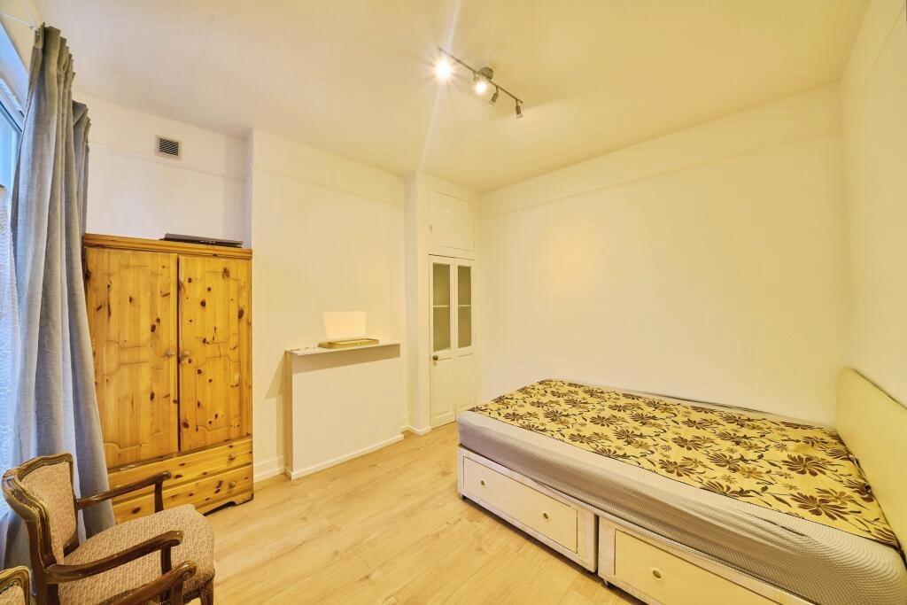 Bright, simply furnished bedroom with wood-effe...