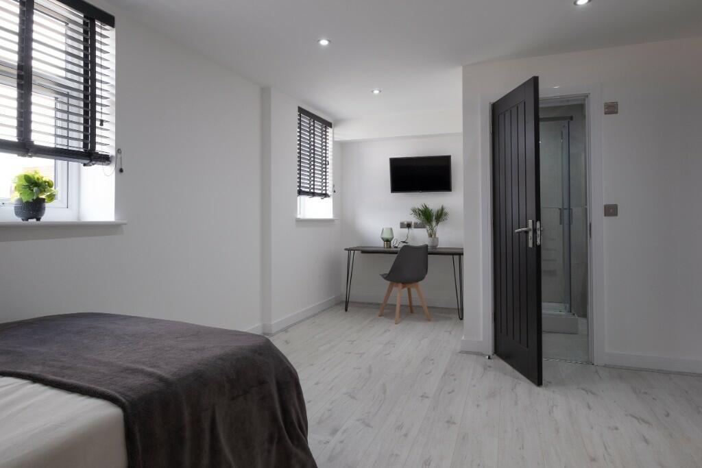 Bright, modern double bedroom with light wood f...