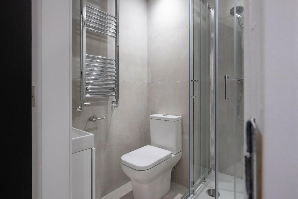 Modern, well-kept bathroom featuring a corner g...
