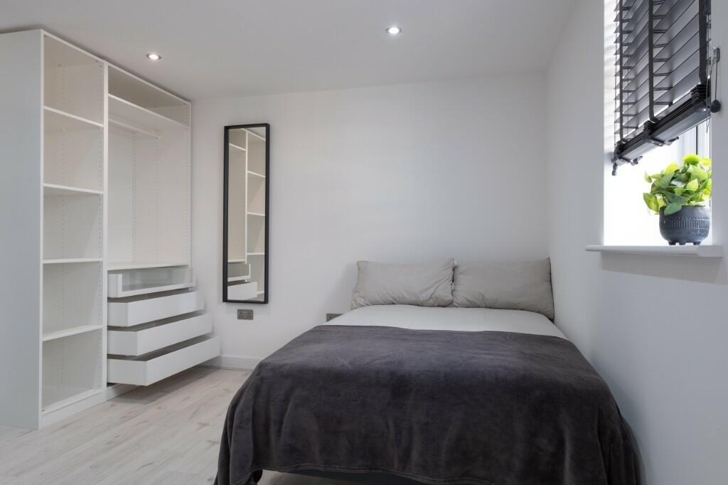 Bright, modern double bedroom with a comfortabl...