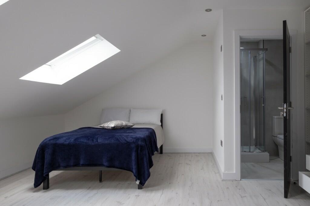 Bright, minimalist attic double bedroom with a ...
