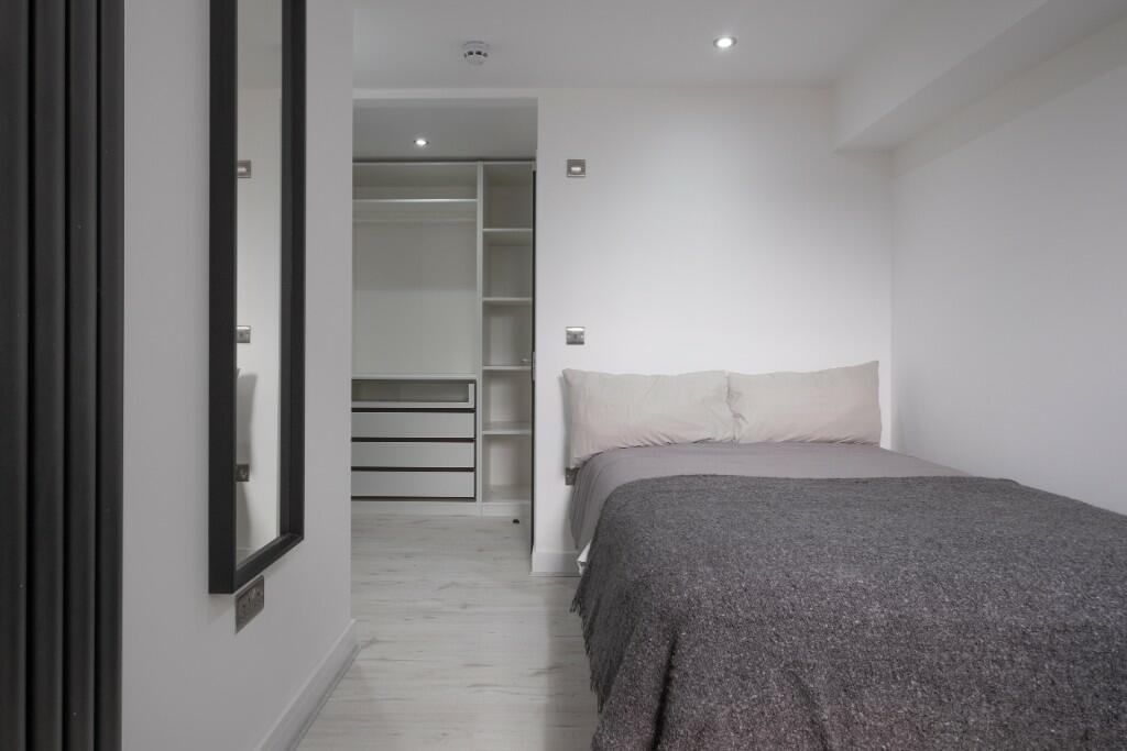 Neat, modern double bedroom with neutral decor,...