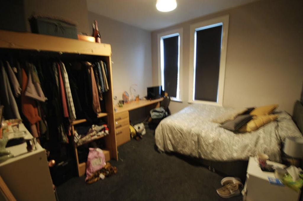A cozy single bedroom featuring a bed, ample na...