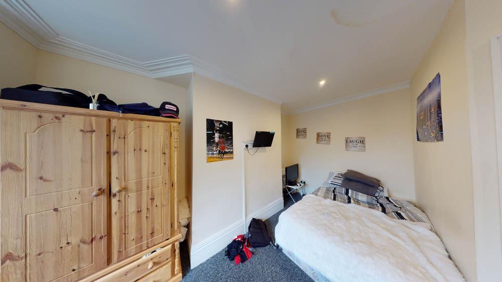 A spacious single bedroom featuring a comfortab...