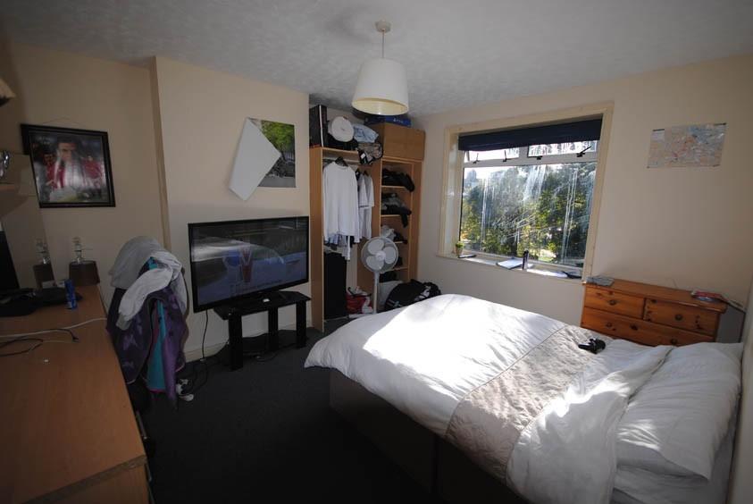 A bright and welcoming bedroom featuring a comf...
