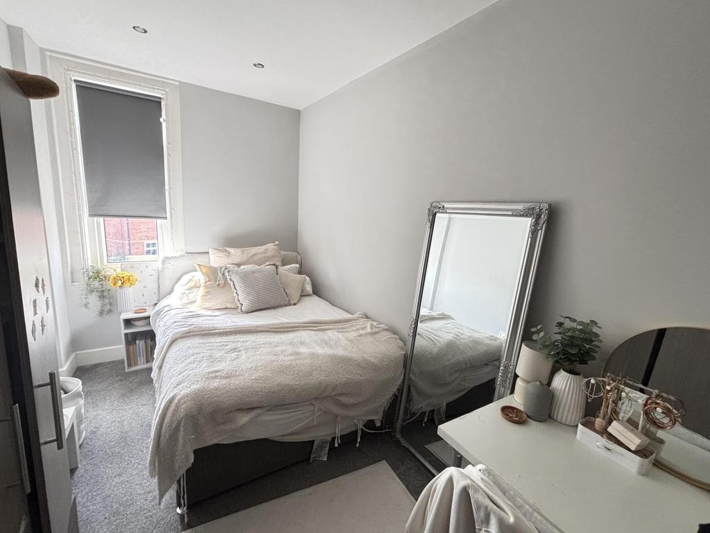 A bright, well-maintained double bedroom with a...