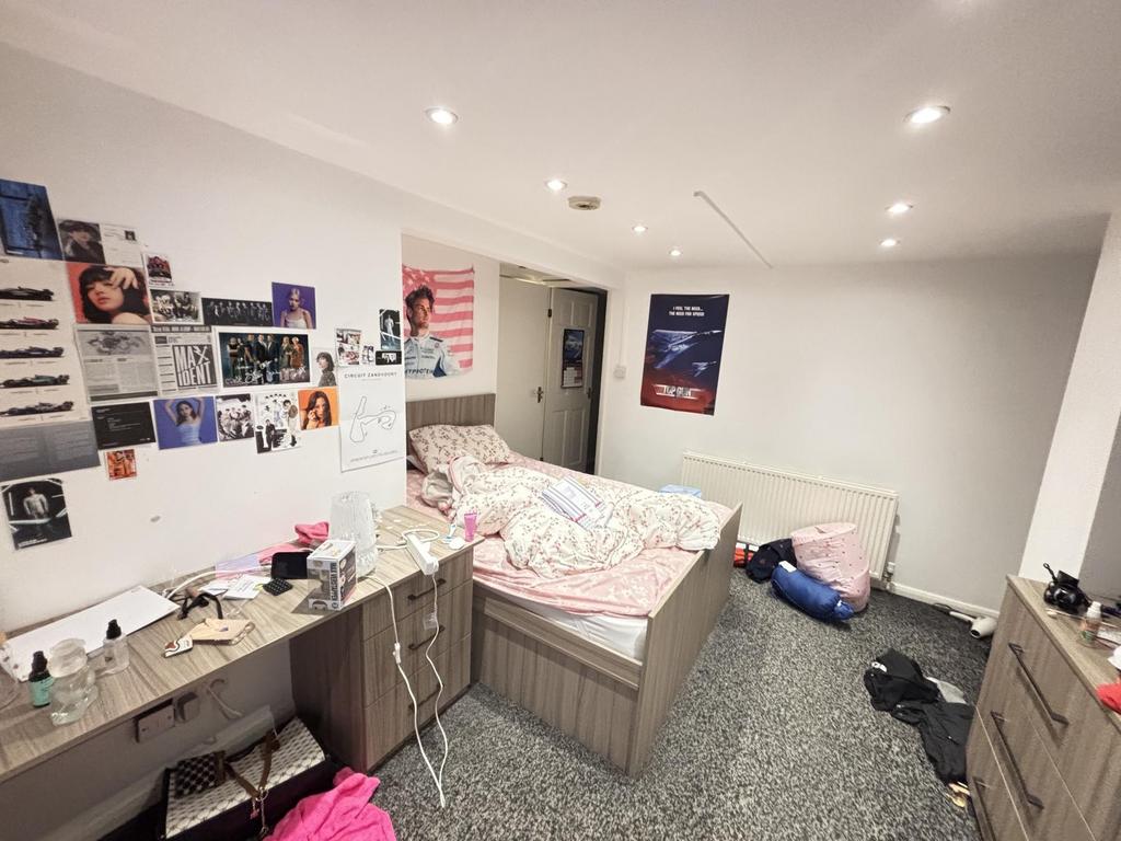 A cozy bedroom with a neat bed covered in a col...