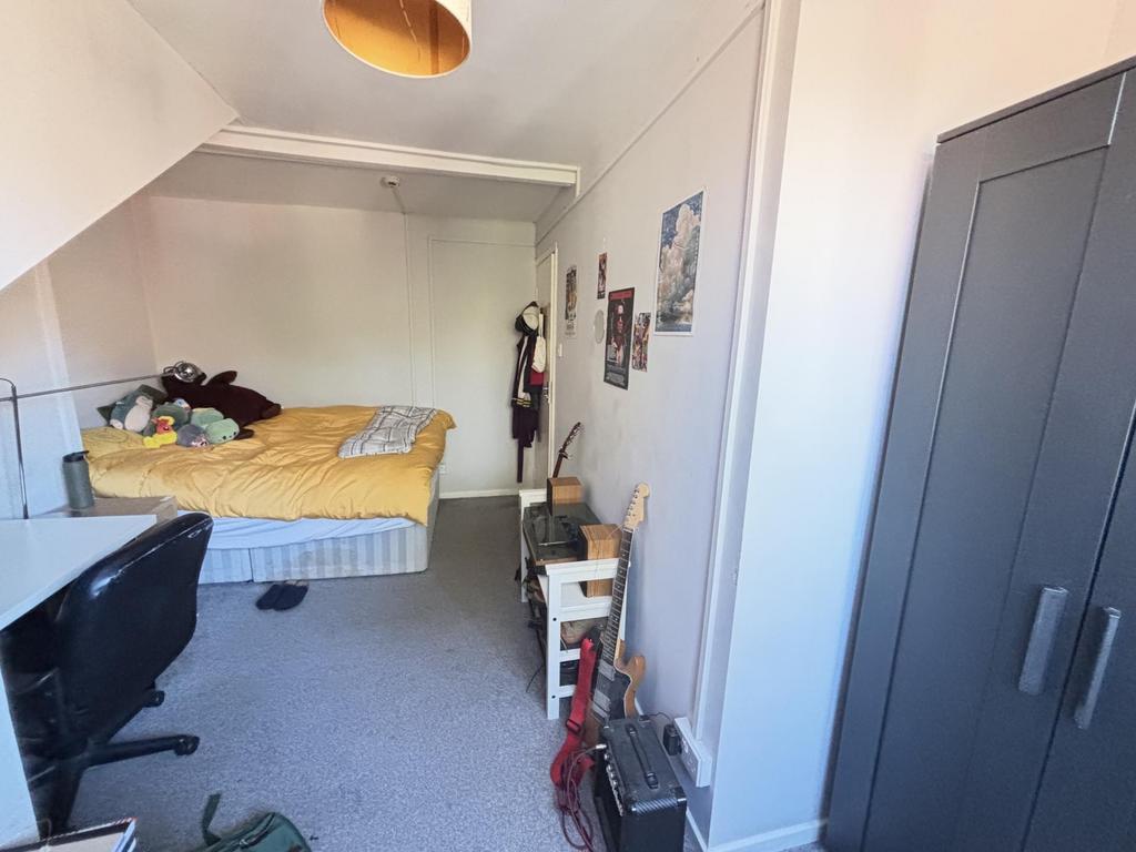 A modest bedroom featuring a double bed with a ...