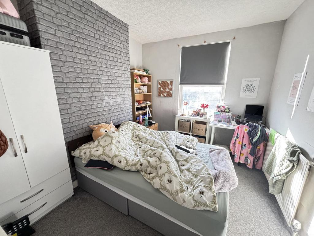A cozy bedroom featuring a bed with plush beddi...