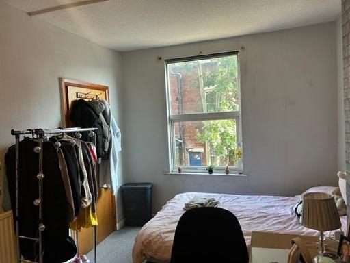 A cozy bedroom featuring a bed positioned near ...