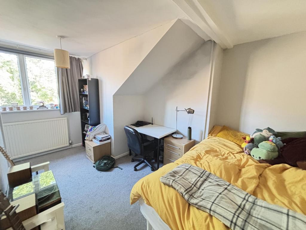 A cozy bedroom featuring a double bed with colo...