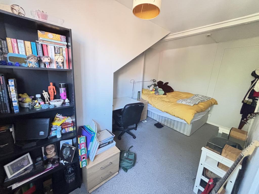 A cozy bedroom with a bed, some personal items,...