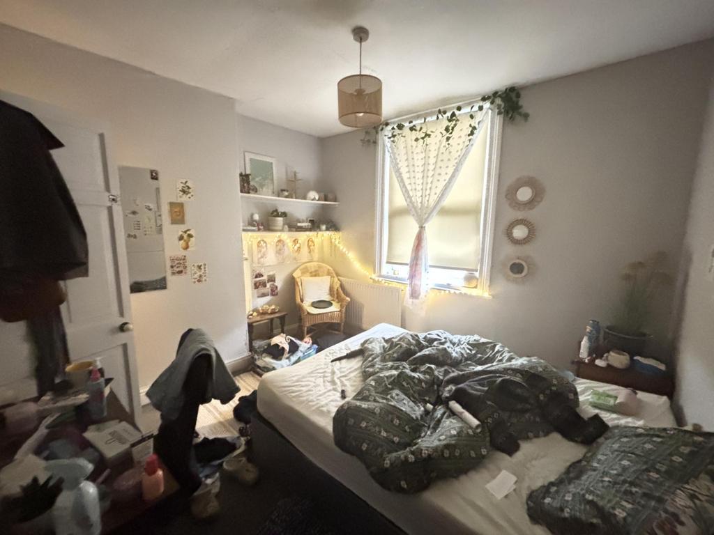 A cozy bedroom featuring a double bed with a wi...