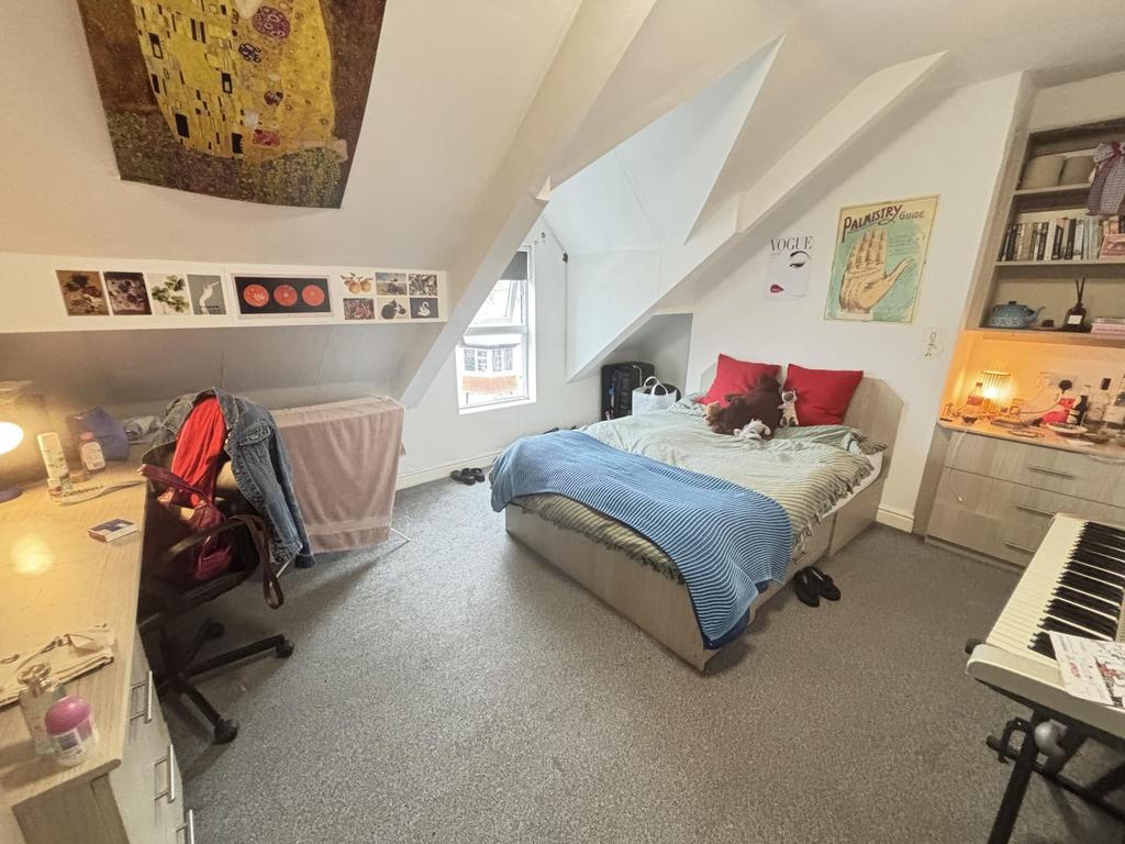 A cozy and well-lit bedroom featuring a large b...
