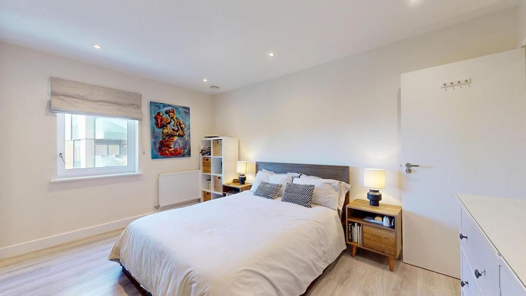 A bright and inviting bedroom featuring a comfo...