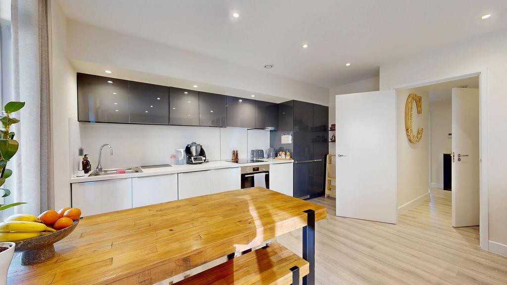 Modern, bright kitchen featuring sleek cabinetr...