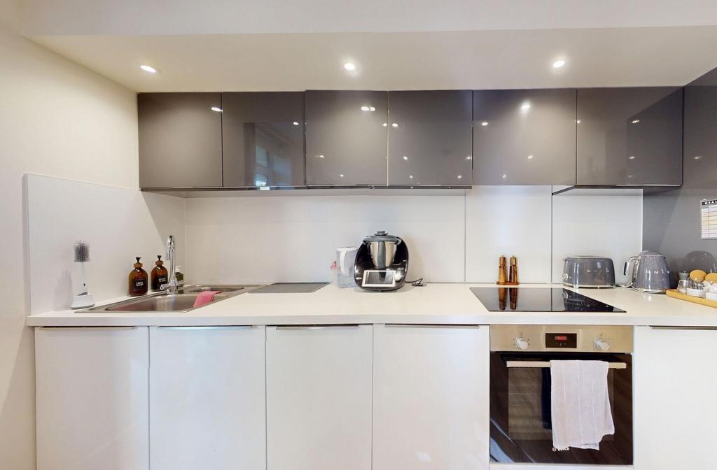Modern kitchen with sleek white cabinets, stain...