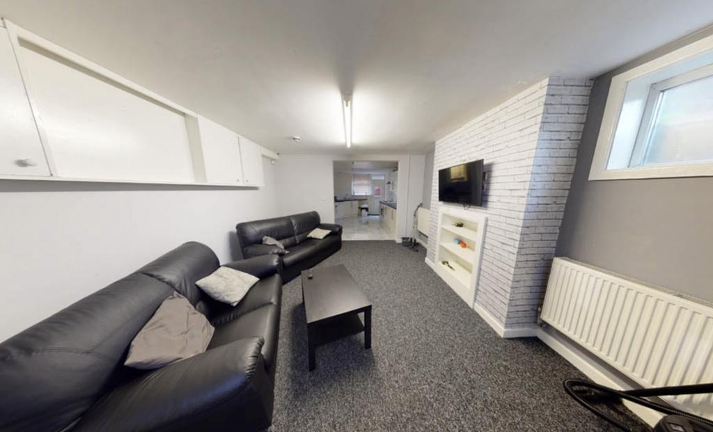 A spacious, well-lit living room featuring comf...