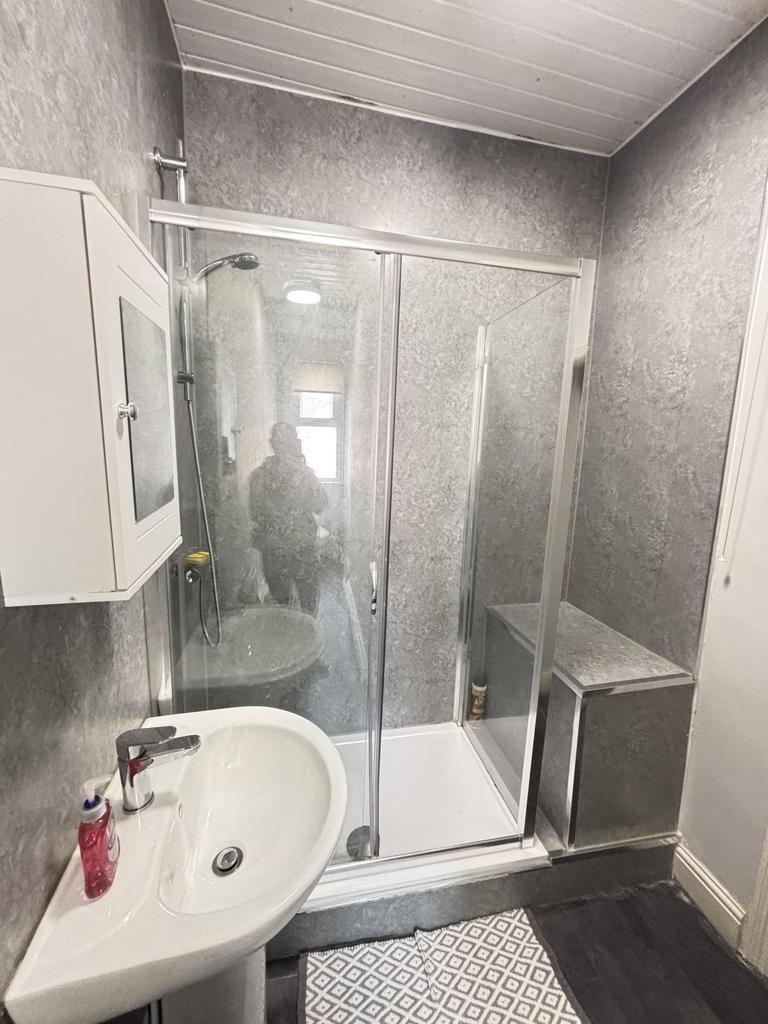 A modern bathroom featuring a spacious shower c...