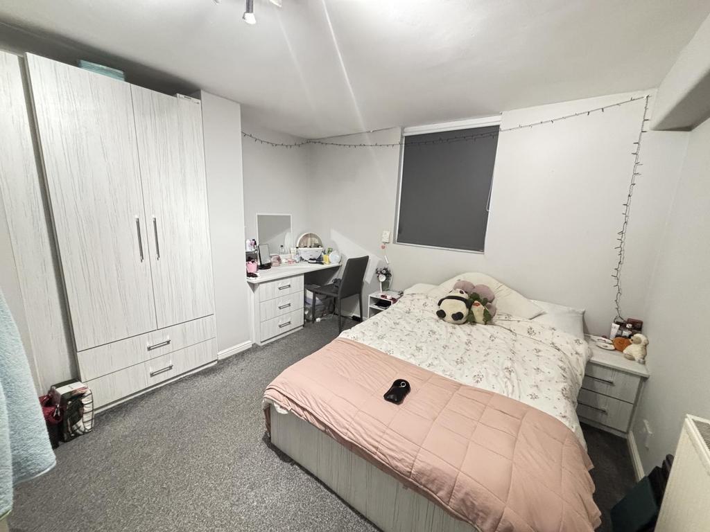 A bright and tidy bedroom featuring a large bed...