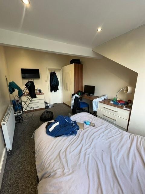 A cozy bedroom with a neatly made bed, featurin...