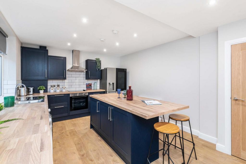 Modern and well-lit kitchen with sleek dark cab...