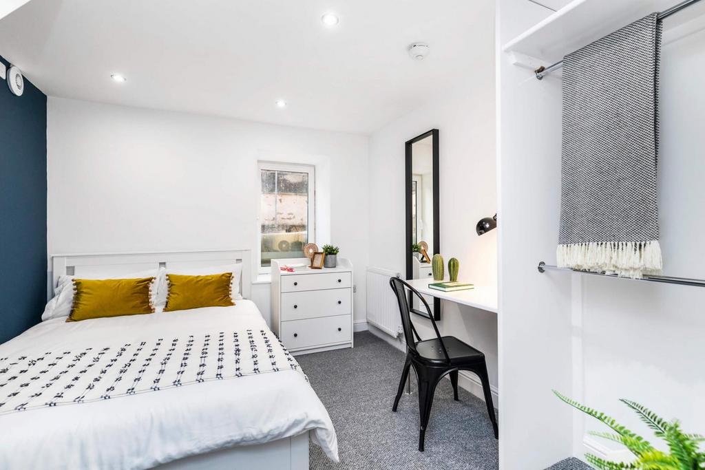 A bright and inviting bedroom featuring a doubl...