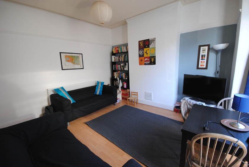 A spacious and well-lit living room featuring c...