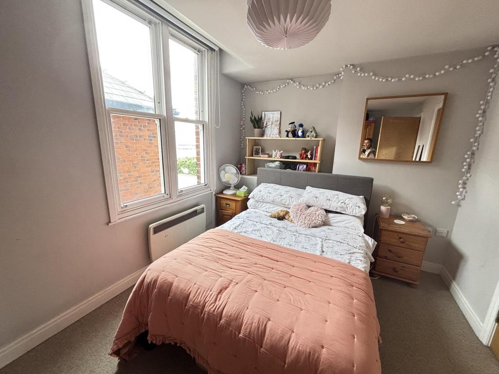 A bright and welcoming master bedroom featuring...