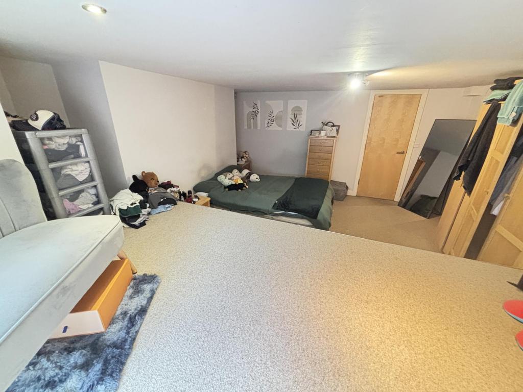 A cozy bedroom featuring a double bed, cluttere...