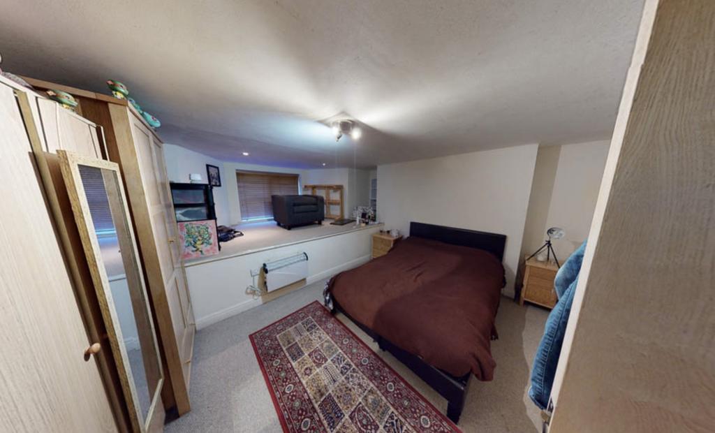 A cozy bedroom featuring a double bed with a da...