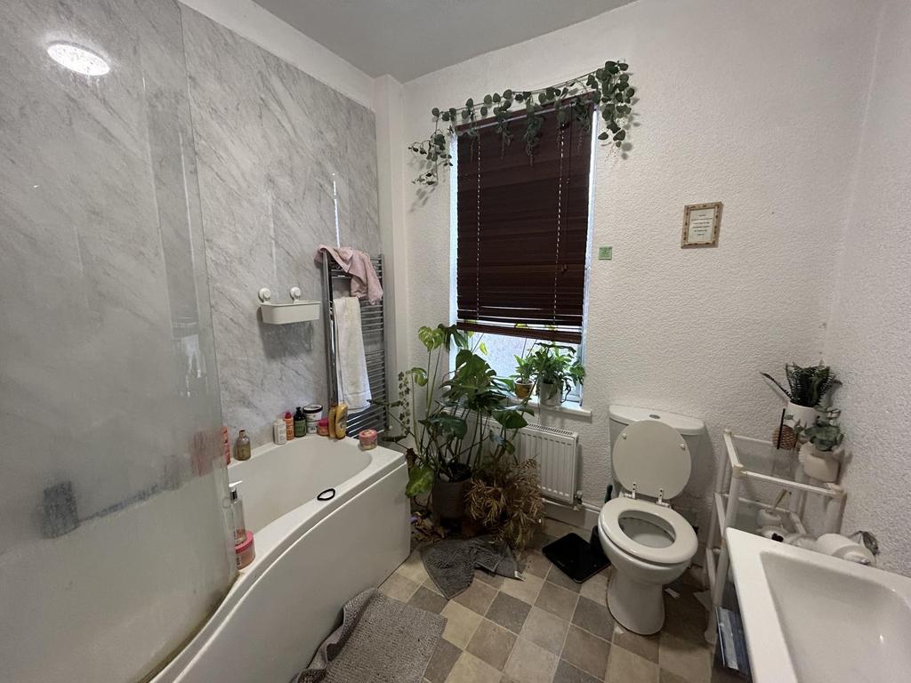 Bright and clean bathroom with a bathtub, toile...