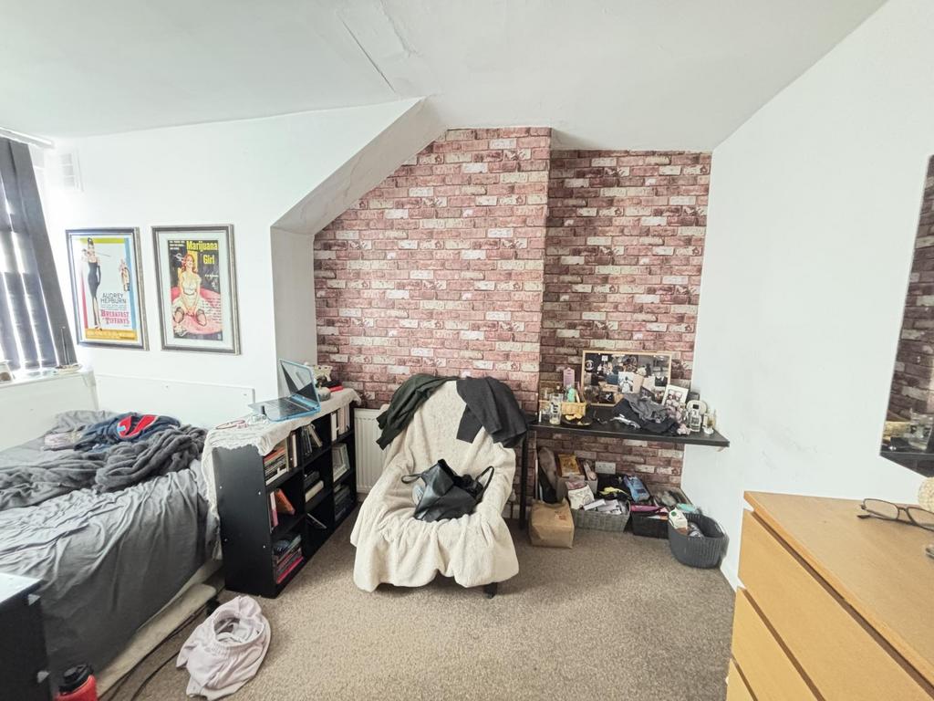 A cozy bedroom featuring a single bed, a study ...
