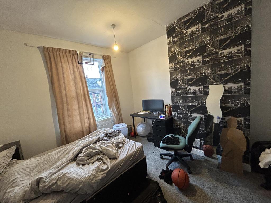 A cozy bedroom featuring a single bed, a study ...