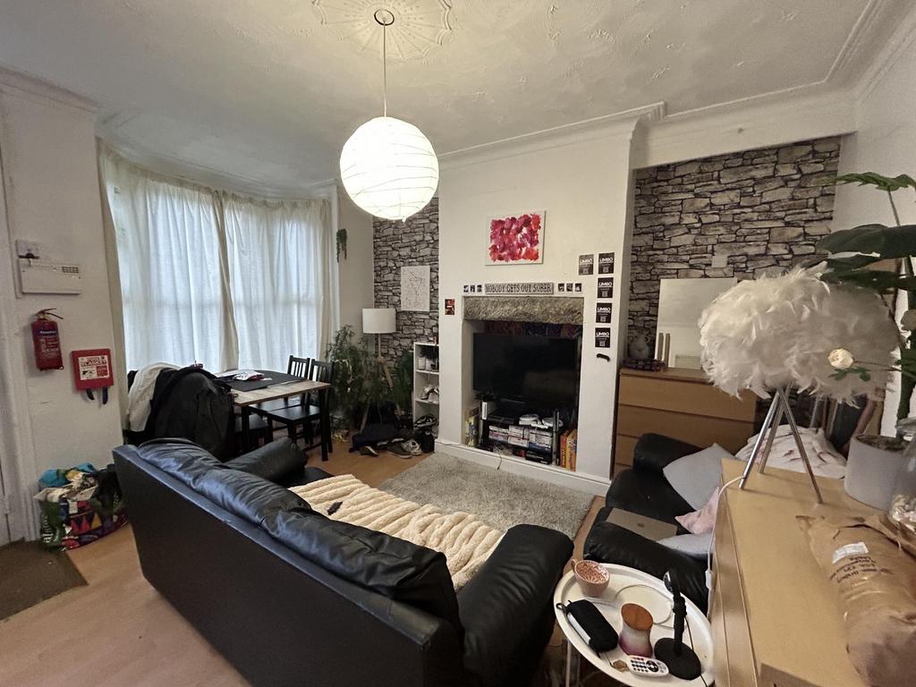 A spacious and cozy living room with ample natu...