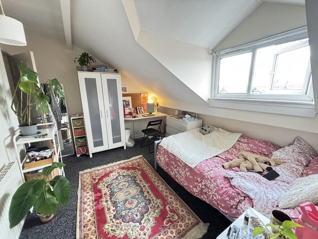 A cozy bedroom with a large window allowing nat...