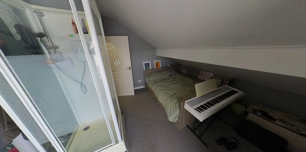 A cozy bedroom featuring a single bed, a desk a...