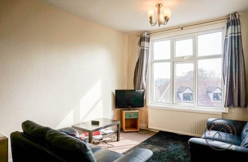 A bright and welcoming living room with a large...
