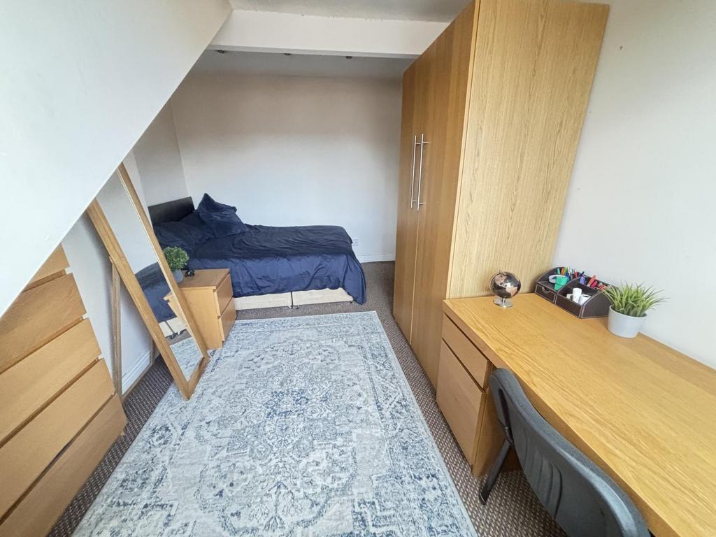 A neat and cozy single bedroom featuring a bed,...
