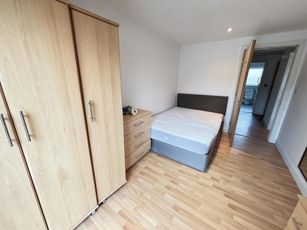 A clean and bright bedroom featuring a comforta...