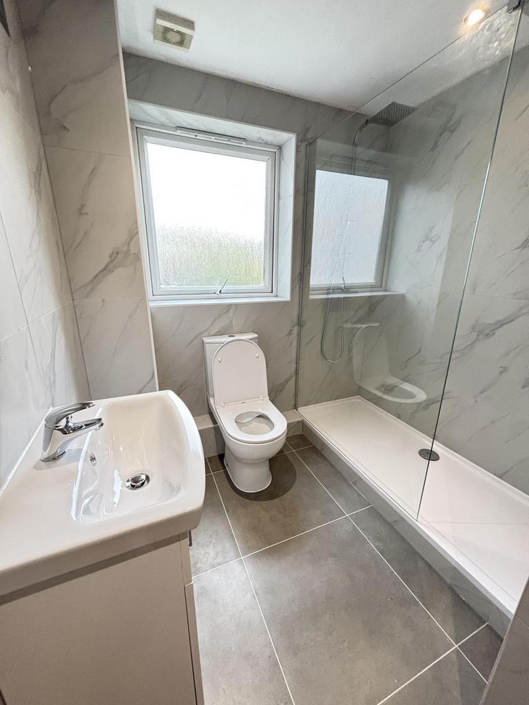 A modern, clean bathroom featuring a large wind...