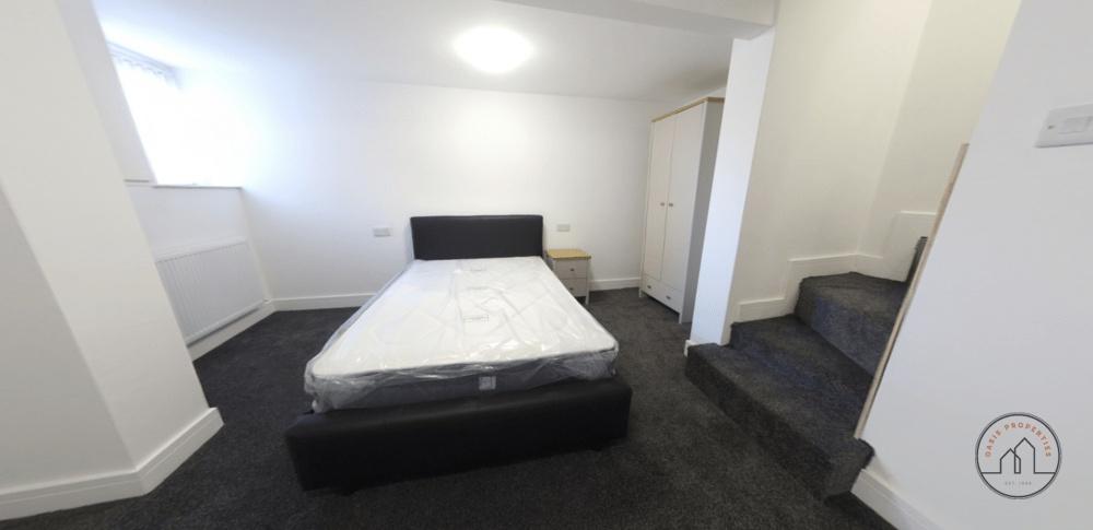 A tidy and well-lit bedroom featuring a double ...