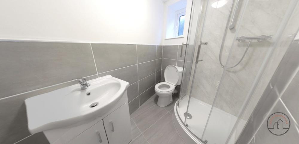 A modern, clean bathroom featuring a large show...